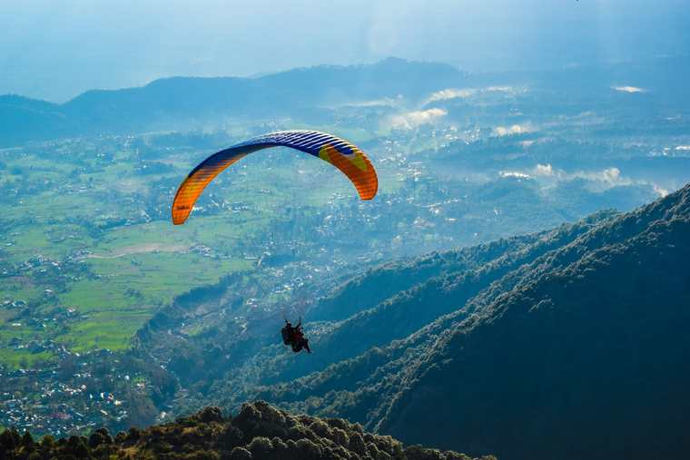 Paraglider over the Bir valley below Billing